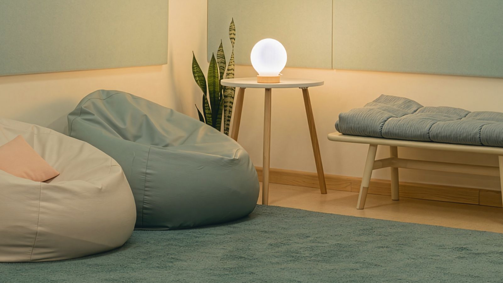 A quiet room with soft bean bags, a weighted blanket and a small lamp (concept image)